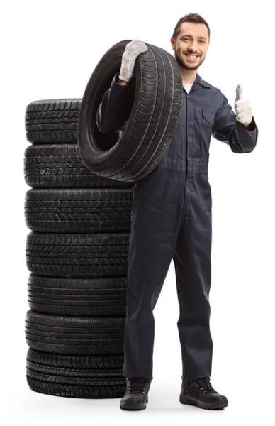 Mechaniker-neben-Altreifenstapel-Daumenhoch Mechaniker signalisiert mit hochgestreckten Daumen das die Altreifen alle Anforderungen zur Entsorgung erfüllen